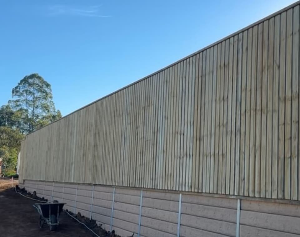 Long timber fence on retaining wall built by Tough Reliable Fencing on the Gold Coast